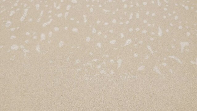 close up to Sea waves rolling over the fine sand beach, waves break on white sand beach with beautiful foam, tropical summer vacation holiday nature background