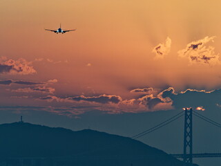 夕暮れの明石大橋と着陸してくる飛行機