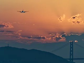 Foto op Plexiglas 夕暮れの明石大橋と着陸してくる飛行機 © Yoshihiro