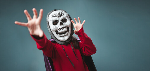 A little girl is wearing a devil costume for Halloween.