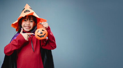 A little girl is wearing a witch costume for Halloween.