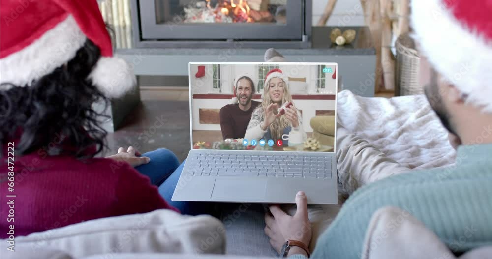 Wall mural Two happy diverse couples having christmas laptop video call, slow motion