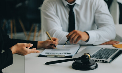 Judge gavel with Justice lawyers having team meeting at law firm in background. Concepts of law.
