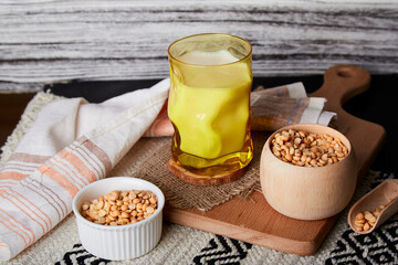 Natural vegan plant based milk - pea milk in creative yellow glass lactose free nutrition.