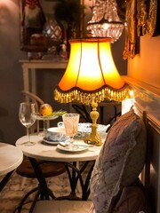 table with a lamp in the interior of an old house, evening - obrazy, fototapety, plakaty
