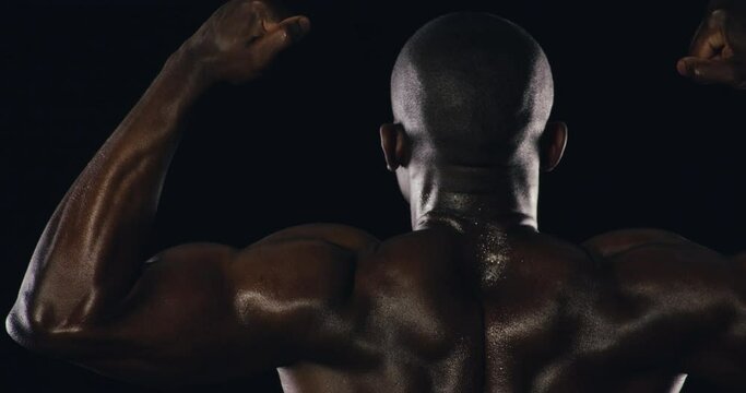 Athlete, flexing or back of strong man in studio for fitness results or wellness on black background. Muscle, model or healthy African bodybuilder ready for workout, sweating or exercise for power