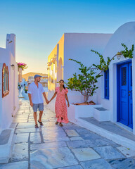 Couple walking at the Greek village of Oia Santorini Greece, men and women on vacation in Greece - obrazy, fototapety, plakaty