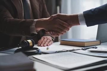 Foto op Aluminium Lawyers shake hands with business people to seal a deal with partner lawyers or a lawyer discussing contract agreements, handshake concepts, agreements. © Phimwilai