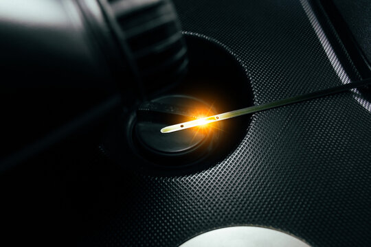 Car engine oil dipstick with reflective light on engine oil cap in engine compartment Car maintenance concept