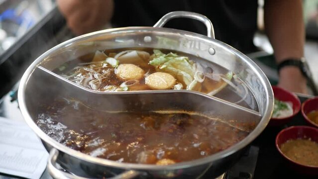 Chinese spicy hot pot cuisine while cooking meatball, fishball and wanton in hot boil chinese style soupbase