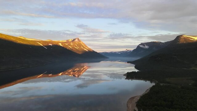 Beautiful Lagoon And Beach Surrounded By Trollheimen Mountains. Sunrise view of  Gjevilvatnet In Oppdal, Norway. wide aerial