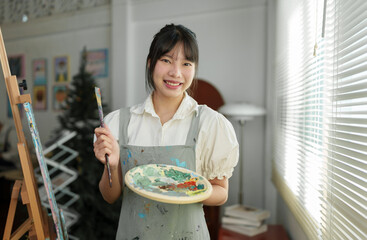 Young female student studying in the art studio Learn how to draw landscapes Mixing watercolors to...