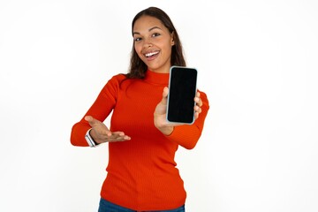 Naklejka premium Beautiful girl wearing red sweater with a mobile. presenting smartphone. Advertisement concept.