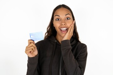 Astonished positive young beautiful woman arm face hold bank plastic card impressed functions