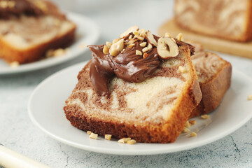 A piece of marble biscuit with chocolate cream and nuts