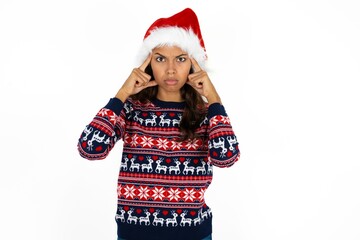 Serious concentrated Beautiful woman wearing christmas sweater keeps fingers on temples, tries to ease tension, gather with thoughts and remember important information for exam