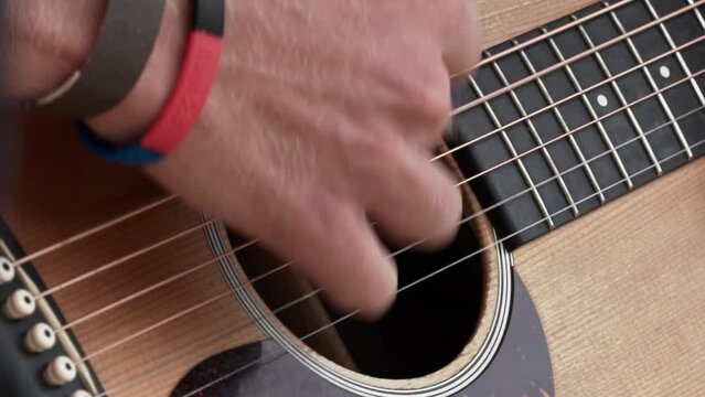 A Man Playing the Guitar by Strumming It - Slow Motion