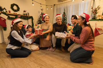Happy Asian family with with multi generations celebrating christmas with gifts in living room with...