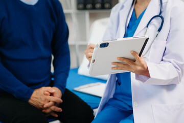 Doctor discussing treatment with Senior male patient talking and laughing sitting on examination bed in clinic or hospital