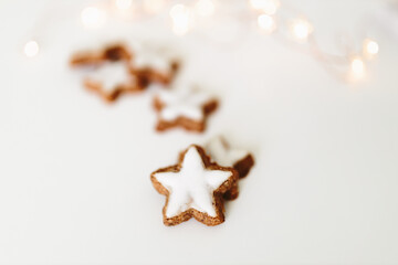 Gingerbread cookies in the shape of stars on a white table against a background of bokeh of New...