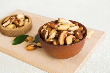 Fresh healthy Brazil nuts in bowl on colored table background. Top view Healthy eating bertholletia concept. Super foods