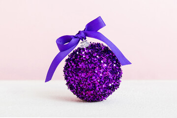 Christmas ball on colored background. decoration bauble with ribbon bow with copy space