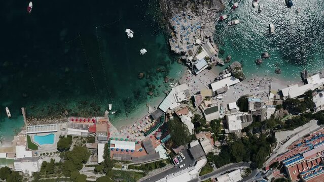 Top down aerial view of Capri, Italy's shoreline on a sunny day.
