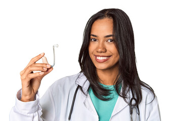 Young Filipina doctor holding hearing amplifier in studio