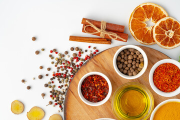 Bowls with spices on wooden board on white background