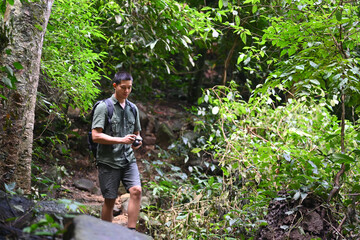 Male hiker with backpack walking along the forest path. Traveling and adventure concept