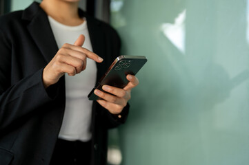 Cropped image of a businesswoman typing on her smartphone. chatting, messaging, texting