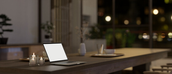 A white-screen laptop mockup on a dining table in a modern, minimal Japanese dining room style.