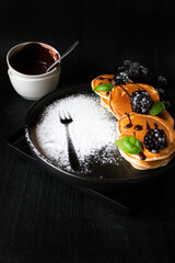 
Pancakes with berries on a black wooden background. dessert. breakfast.