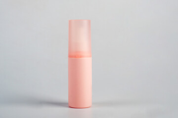 Cosmetic pink bottle. Womens cosmetic accessory for makeup on grey background.