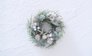 Christmas wreath on white stucco wall. 白い漆喰の背景上のクリスマスリース