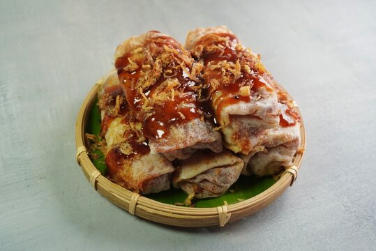 Closeup image of popia basah. This is a traditional Malaysian snack made of soft, thin crepes wrapped around a filling of vegetables.
