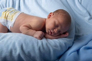 dolcissimo neonato che dorme su una morbida copertina azzurra, 