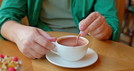 Man drinking hot cocoa sitting in a cafe