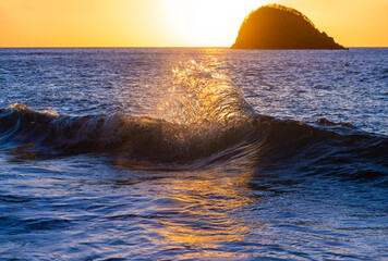 Breaking wave at “Anse Couleuvre“, a remote beach in Martinique France. Caribbean seascape with...