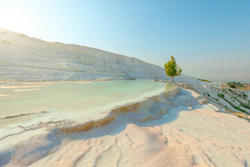 Pamukkale in Turkey reveals its breathtaking thermal pools. Adorned with radiant white terraces, crafted by the mineral-enriched thermal waters cascading down the mountainside.