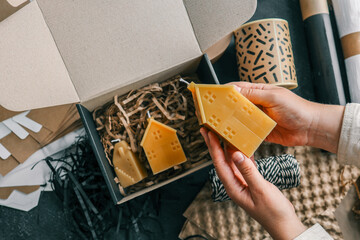 Handmade candle in hands, concept of packaging and delivery of goods