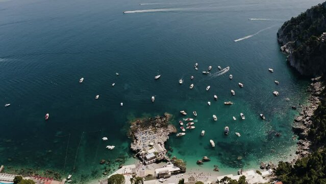 Aerial view of Capri, Italy's shoreline with numerous boats safely moored in the harbor.