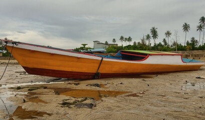 orange boat leaning on the shore