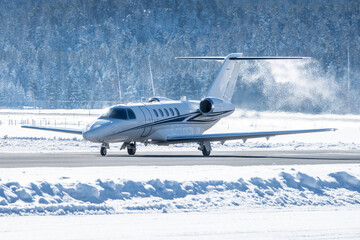 Luxury business jet taking off in engadin valley in the Swiss alps. The airport of Samedan is used...