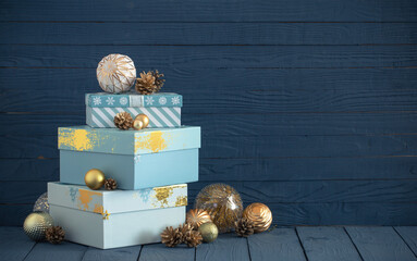 Christmas gifts with golden decorations on blue wooden background