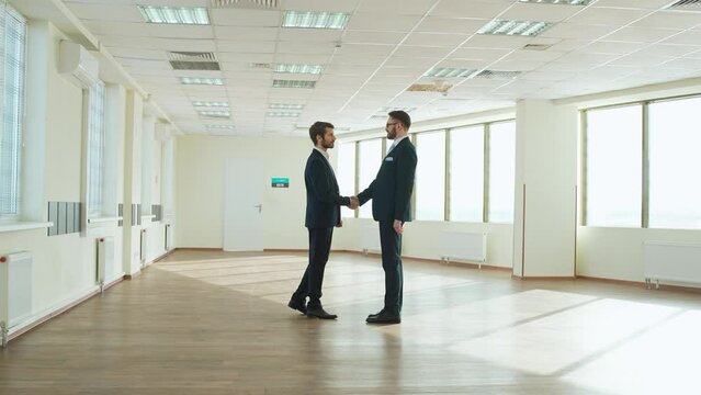 Business meeting, top managers walk to business meet, handshake between businessmen, the interior of a white office space with panoramic windows, inside a skyscraper.