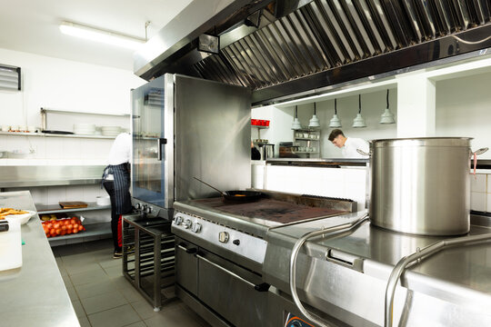 Interior of commercial kitchen with various modern appliances and utensils