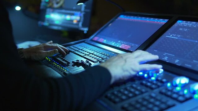Sound engineer at a concert. Equipment for controlling music and sounds at artist performances. Remote control for sound and light in a concert hall. Male hand moves controls and presses buttons