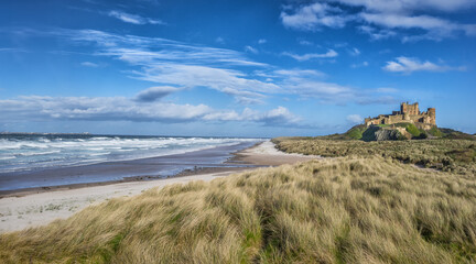 Bamburgh Castle and beach on the coast of Northumberland in England - 668558674