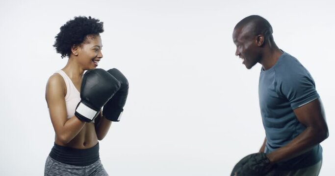 Woman, boxing and black man in studio for fitness, class and punching for martial arts by white background. Boxer girl, personal trainer or coach with mma, fight and workout for wellness in profile